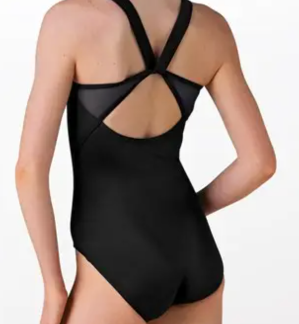 A person viewed from behind modeling a black leotard with mesh panels and criss-cross back straps on a white background
