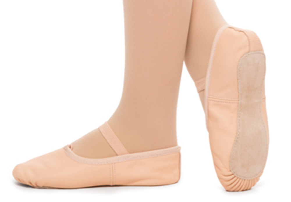 Two feet in light pink leather ballet slippers with elastic straps and suede split soles on a white background one foot facing left the other showing its gathered toe sole