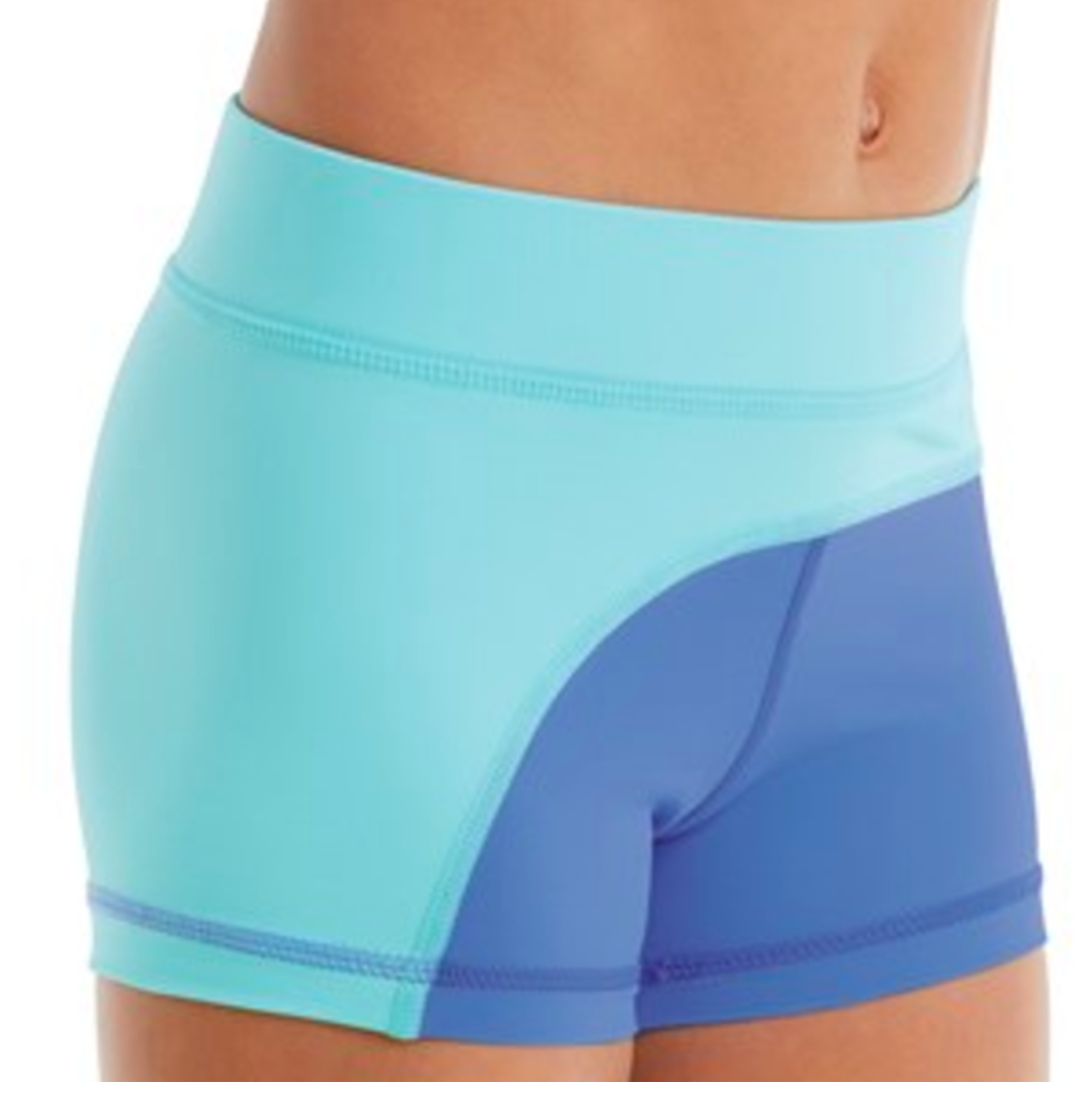 Close-up of a person wearing vibrant aqua and royal blue two-tone athletic shorts featuring a wide waistband and visible flatlock stitching