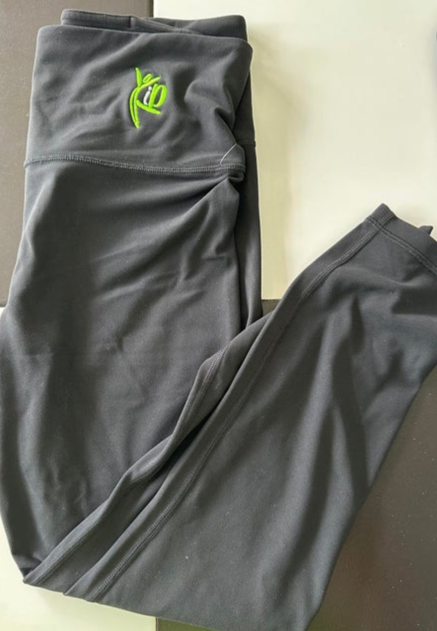 Dark grey activewear leggings featuring a bright neon green embroidered stylized logo on the wide ruched waistband laid flat with visible athletic stitching
