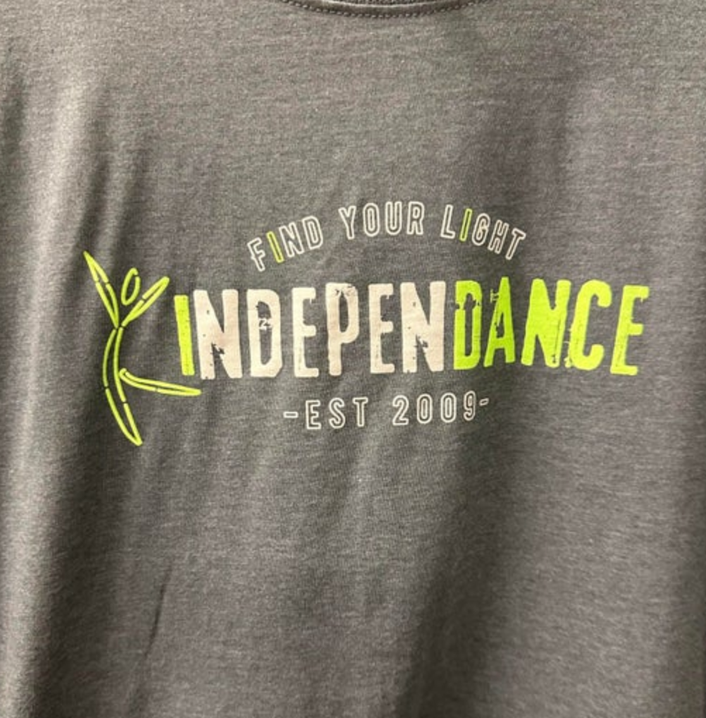 Grey t-shirt with a "Find Your Light" logo featuring "INDEPENDANCE" in distressed white and neon green text with "EST 2009" below, accompanied by a neon green abstract dancer figure on the left