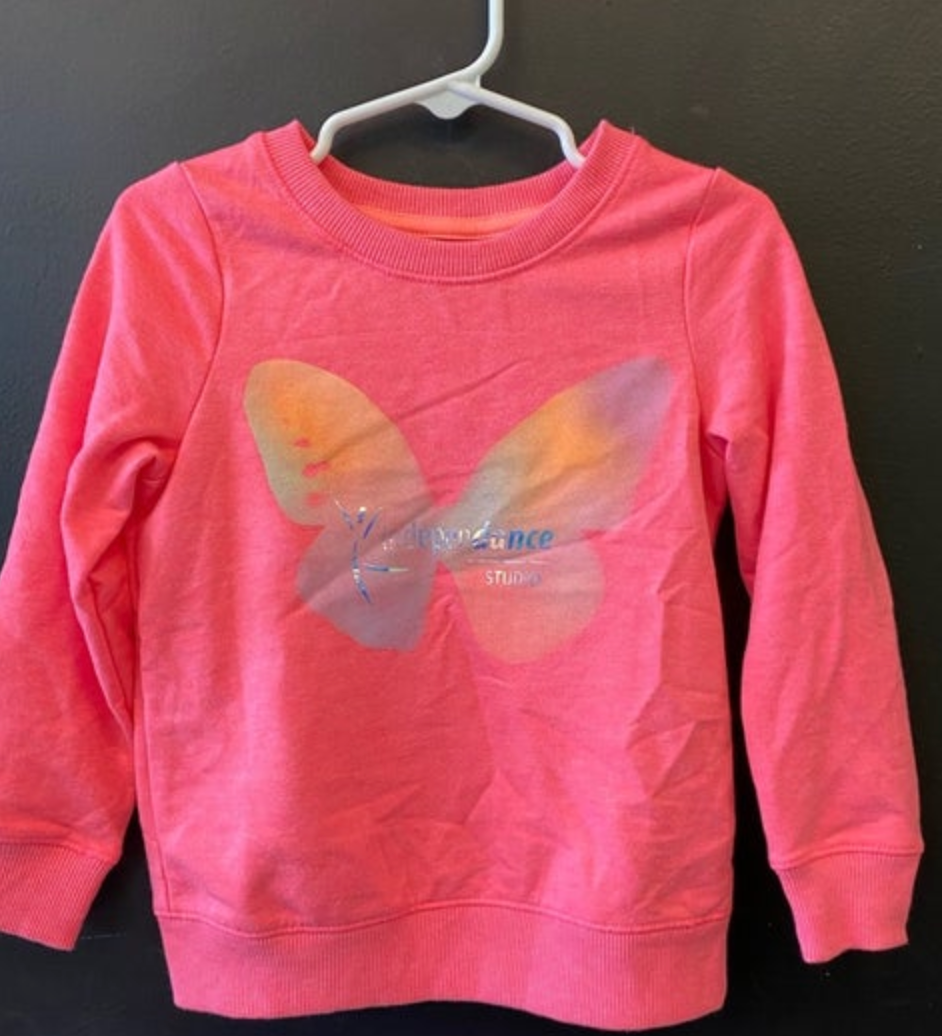 Childrens pink crewneck sweatshirt with an iridescent butterfly graphic featuring a stylized dancer and 'elevance STUDIO' text hanging on a white plastic hanger