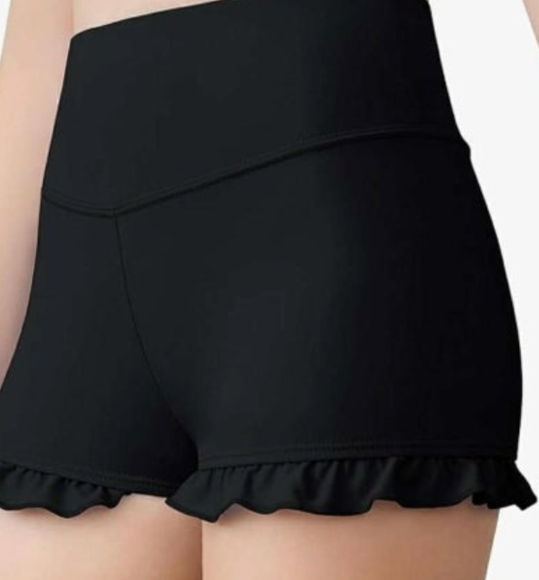 Photograph of black high-waisted shorts with a V-shaped waistband seam and ruffled hems
