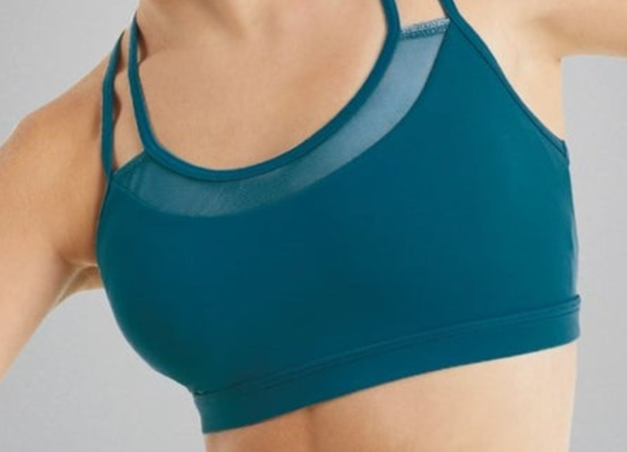 Photograph of a person wearing a teal athletic sports bra featuring mesh paneling at the neckline and thin double shoulder straps