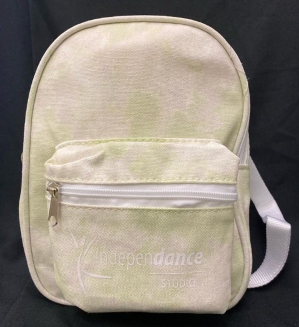 Small canvas backpack with a pale green and white tie-dye pattern featuring a white IndepenDance Studio logo, a white zippered front pocket, and an adjustable strap