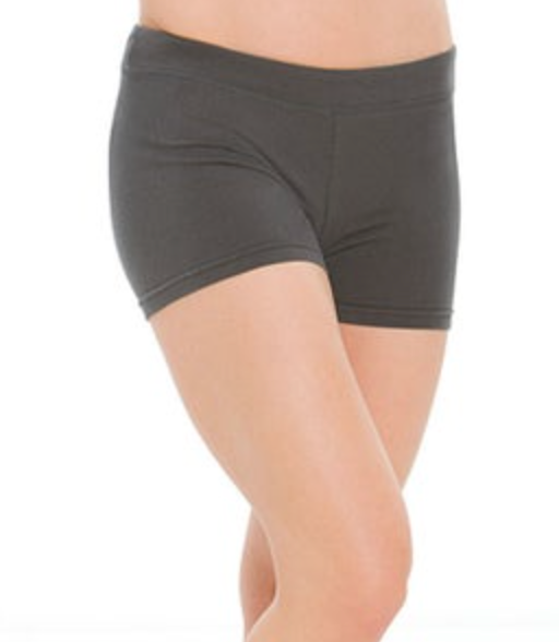 Photograph of a woman modeling dark grey athletic shorts with an elastic waistband showcasing her smooth bare legs against a white background