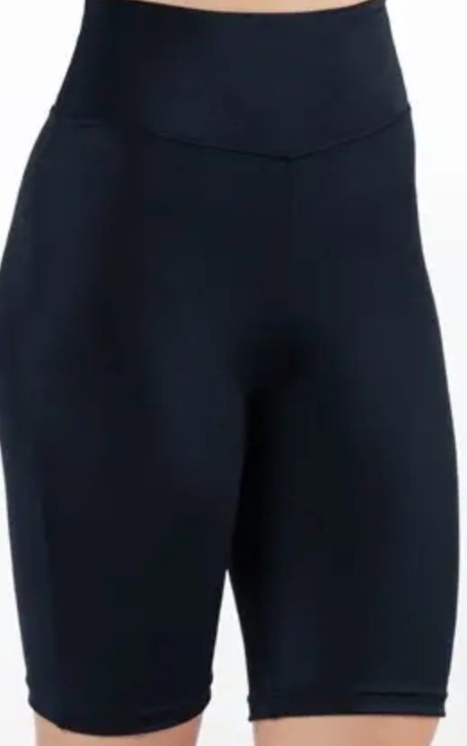 Black high-waisted cycling shorts with a V-shaped front waistband and mid-thigh length on a model