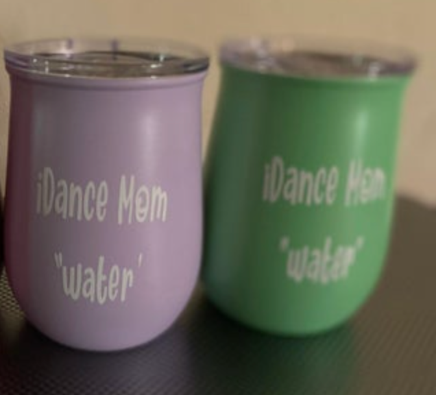 Two stemless tumblers, one vibrant lavender and one lime green, each with a clear lid and white text reading iDance Mom and water in quotation marks